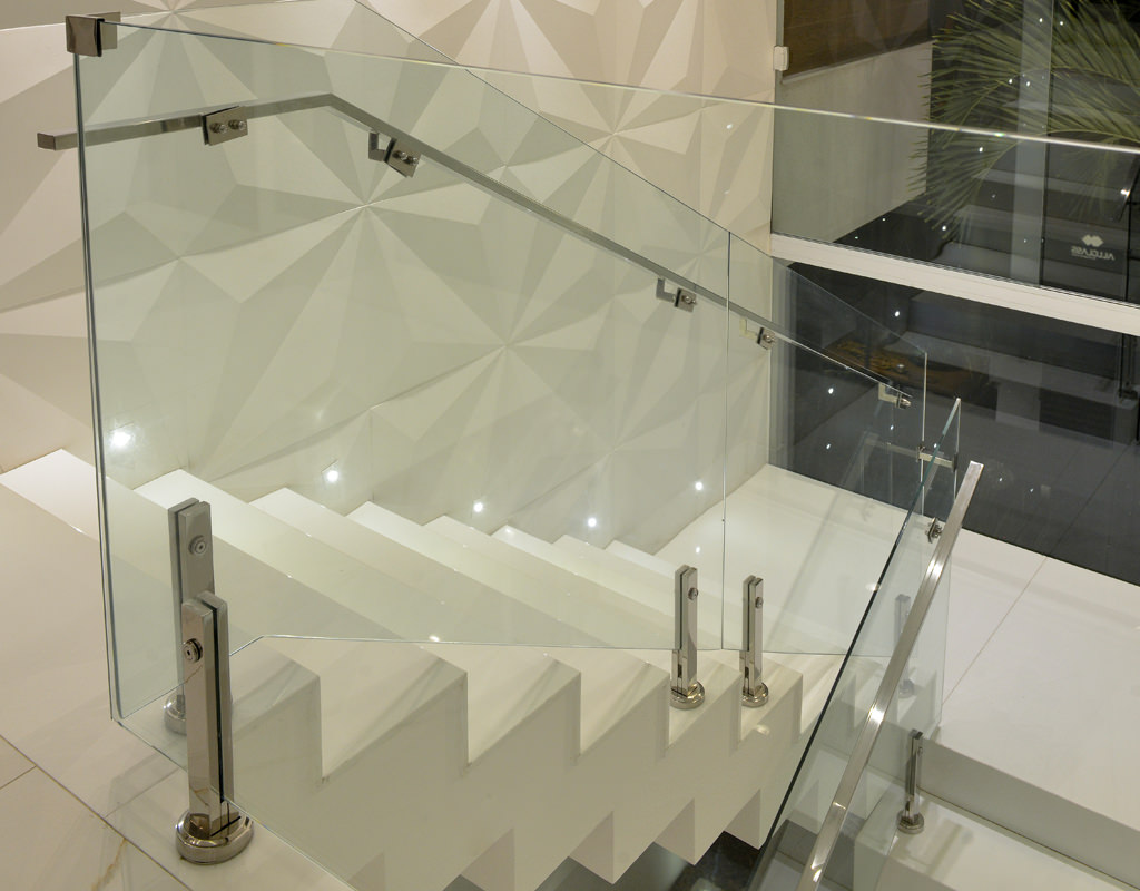 Revestimento em 3D em uma escada branca com corrimão de vidro