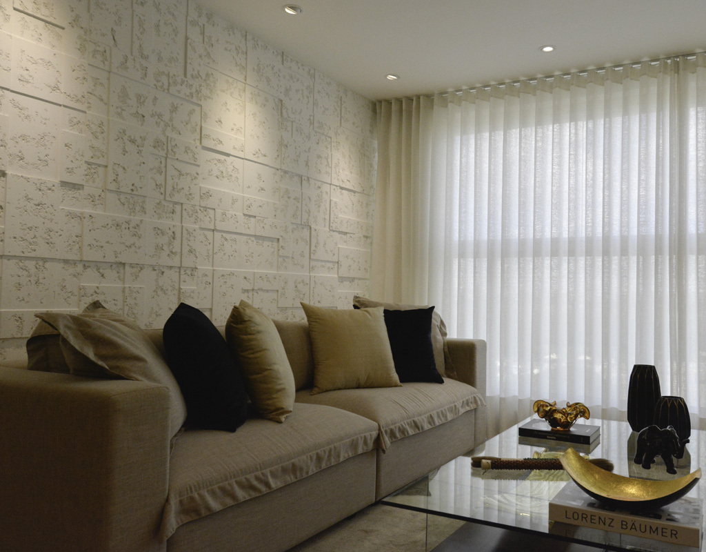 Sala de estar, em tons neutros, parede com revestimento Ártemis Mosaico.